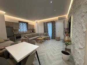 a living room with couches and a table and a kitchen at Vila Floban & MIRDAR KOSHI in Sarandë