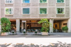 a building with tables and chairs in front of it at Nomad Design & Lifestyle Hotel - Member of Design Hotels in Basel