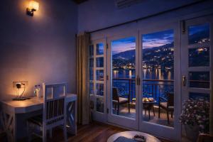 a room with a desk and a window with a view at Neelesh Inn - Luxury Lake View Resort with Swimming Pool on Bhimtal Lake in Bhīm Tāl