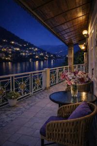 a patio with a table and chairs and a view of the water at Neelesh Inn - Luxury Lake View Resort with Swimming Pool on Bhimtal Lake in Bhīm Tāl