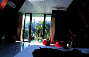 a bedroom with a bed and a large window at Infinite cabana in Ella