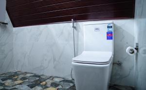 a bathroom with a toilet with a toilet paper dispenser at Infinite cabana in Ella