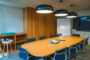 a conference room with a large wooden table and chairs at Nomad Design & Lifestyle Hotel - Member of Design Hotels in Basel