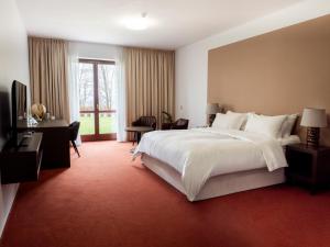 a bedroom with a large bed and a large window at Hotel Cvilín in Krnov