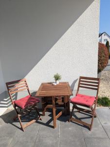 a wooden table and two chairs sitting next to at Apartment del Mardy in Ostfildern