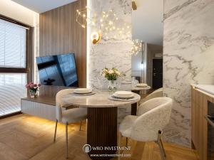 a dining room with a table and chairs in a kitchen at Apartament Studio Sol Marina in Wiślinka