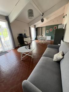 a living room with a couch and a table at Cottage les Écuries du faubourg in Béthune