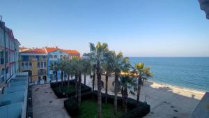 a view of a beach with palm trees and buildings at TRILOCALE DIRETTAMENTE SUL MARE - cod 512 in Porto Recanati