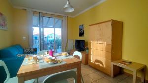 a living room with a table and a blue couch at TRILOCALE DIRETTAMENTE SUL MARE - cod 512 in Porto Recanati