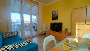 a living room with a blue couch and a table at TRILOCALE DIRETTAMENTE SUL MARE - cod 512 in Porto Recanati +13 photos