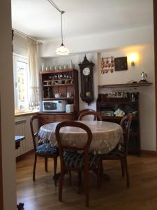 a dining room with a table and chairs and a clock at Luca Residence in Timişoara
