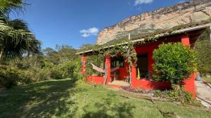 a red house with vines growing on the side of it at Casa Morro Branco in Palmeiras