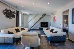 a living room with white couches and a staircase at RG Duplex - LRA Cannes in Cannes