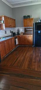 a kitchen with wooden cabinets and a black refrigerator at Himmel Haus in Laguna +6 photos