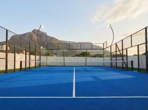 a tennis court with a mountain in the background at The City Club in Cape Town
