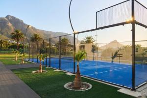 a tennis court with two palm trees and a tennis court at The City Club in Cape Town