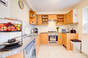 a kitchen with wooden cabinets and a dishwasher at Smart Studio- North London - Sleeps 2 - free parking in London +7 photos