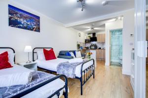 a bedroom with two beds and a living room at Smart Studio- North London - Sleeps 2 - free parking in London