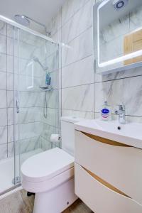 a bathroom with a toilet and a shower and a sink at Smart Studio- North London - Sleeps 2 - free parking in London