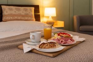 a breakfast tray with a sandwich and fruit on a bed at Hotel Golf Bitozeves in Bitozeves
