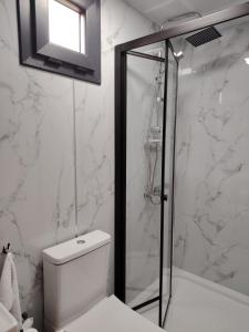 a white bathroom with a shower and a toilet at Haller Camping in Budapest