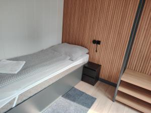 a small bedroom with a bed and a wooden wall at Haller Camping in Budapest +36 photos