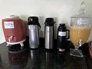 a counter with three coffee makers and a blender at Hotel Realeza in Goiânia