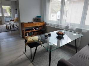a living room with a glass table and a couch at Ferienwohnung Moselherz in Reil