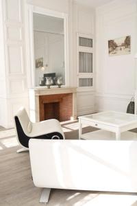 a white living room with a white couch and a table at Suite Luxe · Cour calme · Chartres centre in Chartres