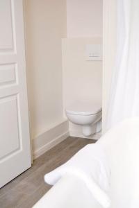 a white bathroom with a toilet and a window at Suite Luxe · Cour calme · Chartres centre in Chartres +6 photos