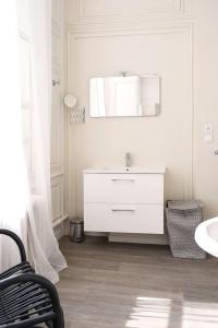 a white bathroom with a sink and a mirror at Suite Luxe · Cour calme · Chartres centre in Chartres
