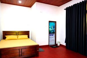 a bedroom with a bed and a black curtain at Thew Guest Wilpattu in Nekattegama