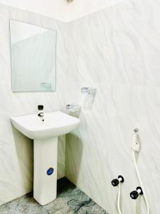 a white bathroom with a sink and a mirror at Thew Guest Wilpattu in Nekattegama