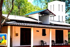 a small white building with chairs in front of it at Thew Guest Wilpattu in Nekattegama
