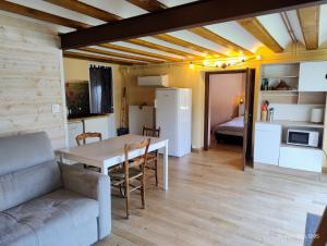 a kitchen and living room with a table and a couch at Chambre d'hôtes Park des Collines - Gîte in Génissieux