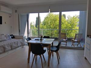 a living room with a table and chairs and a large window at Lenn Rem Eze in Ezeiza