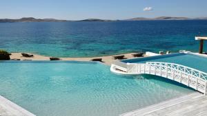 a large swimming pool with a view of the ocean at Saint John Hotel Villas & Spa in Agios Ioannis Mykonos