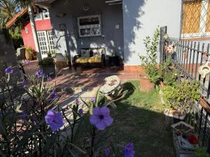 a garden with purple flowers in front of a house at Cuatro Soles in Ezeiza