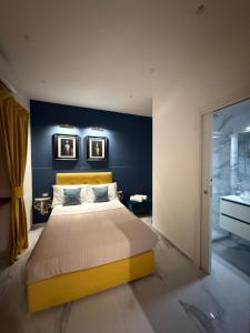 a bedroom with a large bed with a blue wall at Frida Kahlo appartament in Lacco Ameno