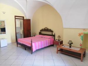 a bedroom with a pink bed and a table at TeNuTa Li Frasulli in Sannicola