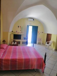 a bedroom with a large bed with a colorful bedspread at TeNuTa Li Frasulli in Sannicola