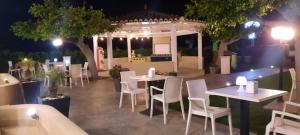 a restaurant with tables and chairs and a gazebo at night at I Settembrini in Capo Vaticano