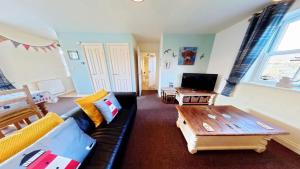 a living room with a couch and a coffee table at Lighthouse Apartment - Part of the The Bay Filey Holiday Village with pool, gym and direct beach access, pub, restaurant, tennis and meadows walks in Filey