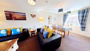 a living room with a couch and a dining room at Lighthouse Apartment - Part of the The Bay Filey Holiday Village with pool, gym and direct beach access, pub, restaurant, tennis and meadows walks in Filey