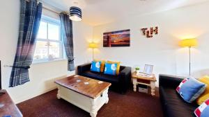 a living room with a couch and a table at Lighthouse Apartment - Part of the The Bay Filey Holiday Village with pool, gym and direct beach access, pub, restaurant, tennis and meadows walks in Filey