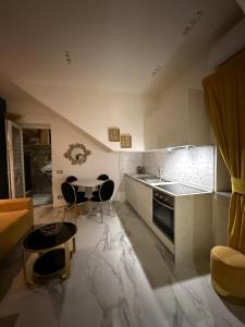 a kitchen with a sink and a table with chairs at Frida Kahlo appartament in Lacco Ameno