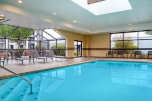 a swimming pool with tables and chairs and windows at Courtyard Columbus Worthington in Worthington