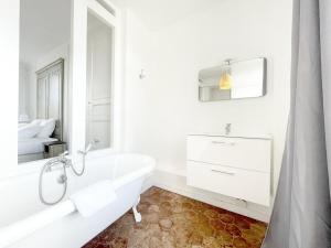 a white bathroom with a tub and a bed at Les Soeurs · Vue cathédrale · Chartres centre in Chartres