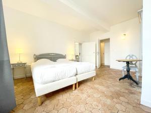 a bedroom with a white bed and a table at Les Soeurs · Vue cathédrale · Chartres centre in Chartres +14 photos