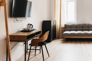 a living room with a desk and a couch at Apartamenty Boutique 9 Sosnowiec in Sosnowiec